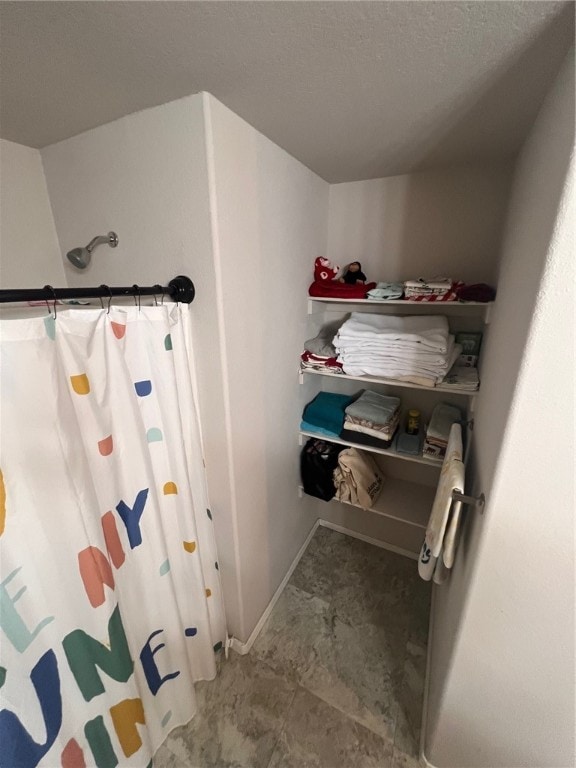 bathroom with a shower with curtain and a textured ceiling