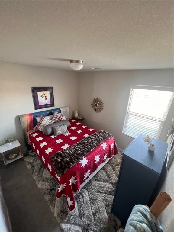 bedroom featuring carpet flooring and a textured ceiling