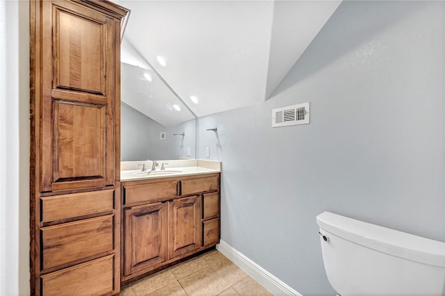 bathroom featuring tile patterned floors, vanity, vaulted ceiling, and toilet