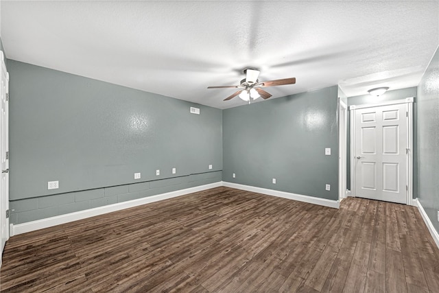 spare room with a textured ceiling, ceiling fan, and dark wood-type flooring