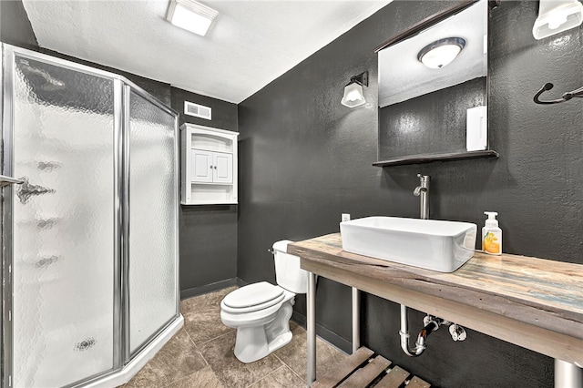 bathroom featuring tile patterned floors, sink, an enclosed shower, and toilet