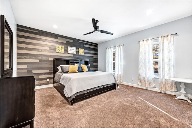 bedroom with carpet flooring, ceiling fan, and wooden walls