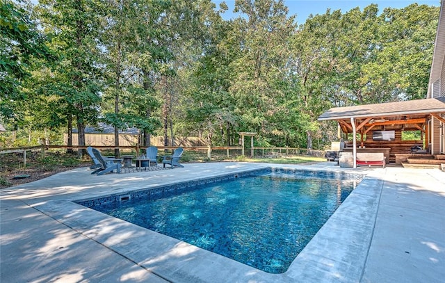 view of pool featuring a patio area, a bar, and an outdoor fire pit