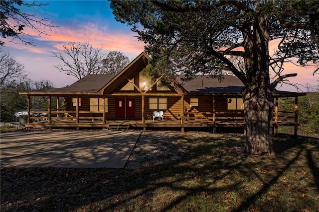 back house at dusk featuring a deck