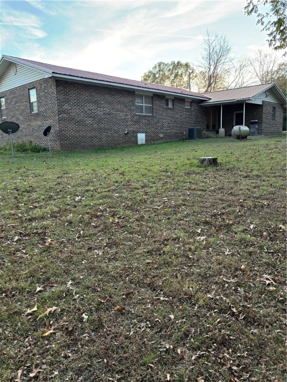 back of property with cooling unit and a yard