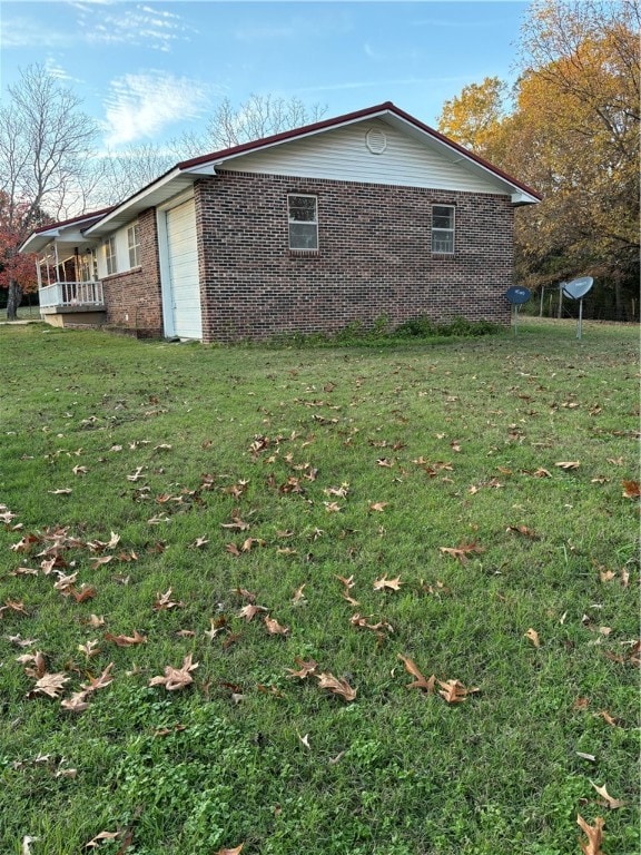 view of side of home with a lawn and a garage