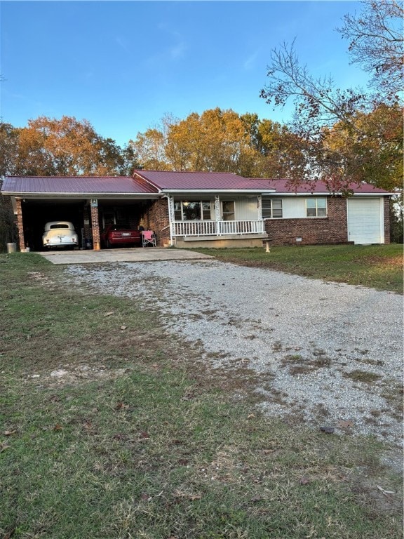 ranch-style home with a front yard, covered porch, and a carport