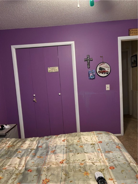 unfurnished bedroom with carpet and a textured ceiling