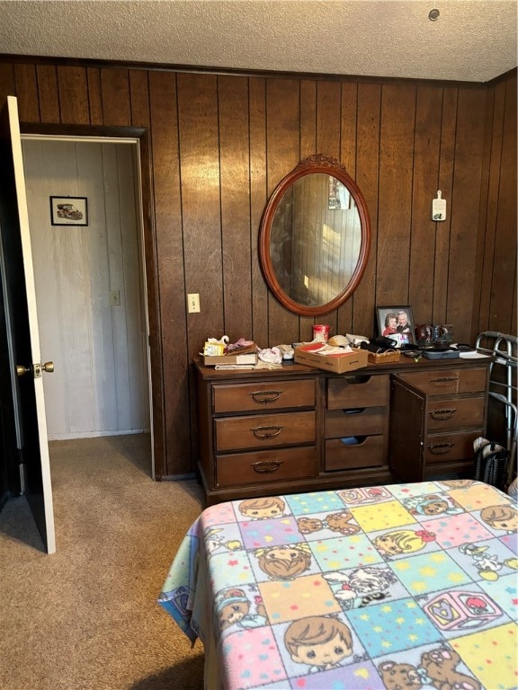 carpeted bedroom featuring wood walls and a textured ceiling