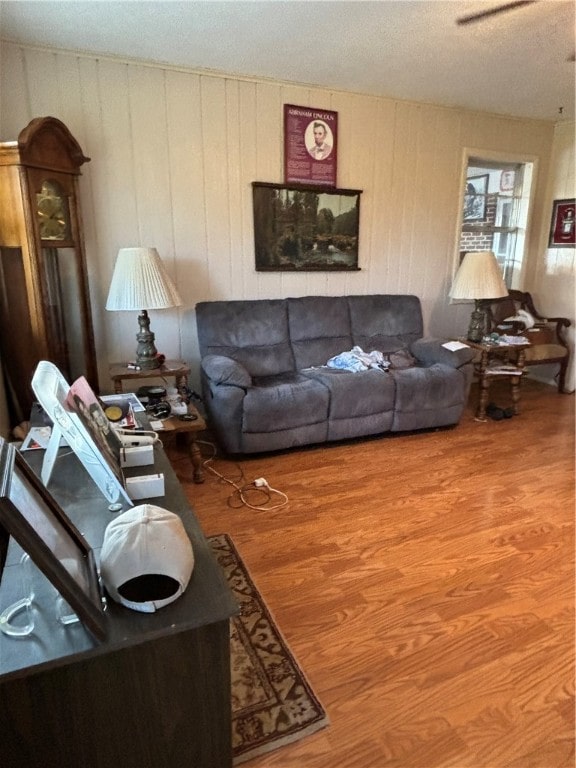 living room featuring a textured ceiling, hardwood / wood-style flooring, and ceiling fan