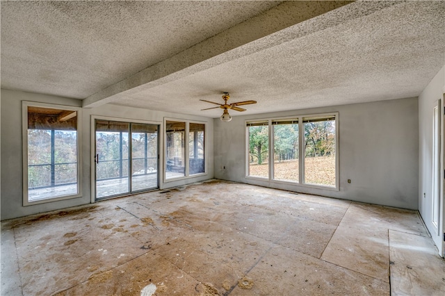 unfurnished room featuring ceiling fan, beamed ceiling, and a textured ceiling