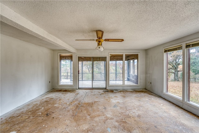 unfurnished room with ceiling fan and a textured ceiling