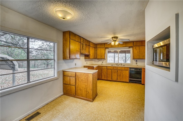 kitchen featuring ceiling fan, sink, a textured ceiling, and black dishwasher