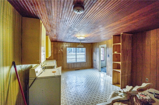 misc room featuring washing machine and dryer, wood ceiling, and wooden walls