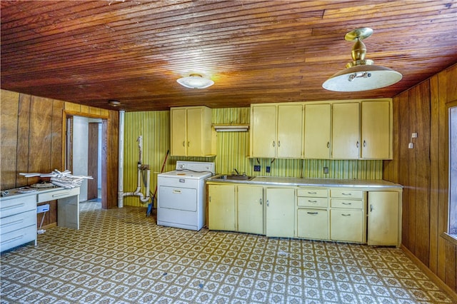 kitchen featuring washer / clothes dryer, sink, wood walls, and wooden ceiling