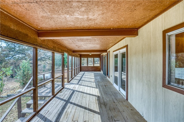 unfurnished sunroom featuring beamed ceiling