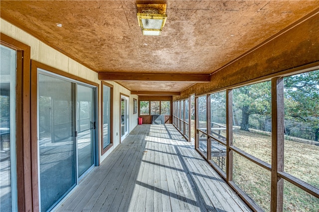 unfurnished sunroom with beam ceiling