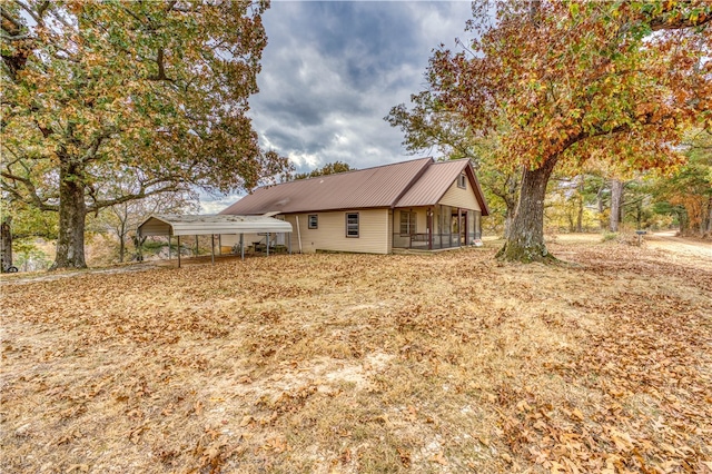 rear view of property with a carport and a sunroom