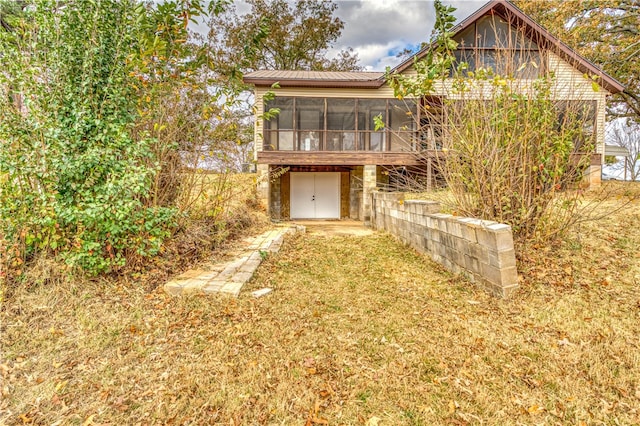 rear view of property with a sunroom and a yard