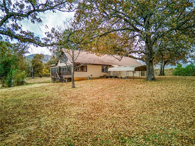 view of yard featuring a sunroom and a carport