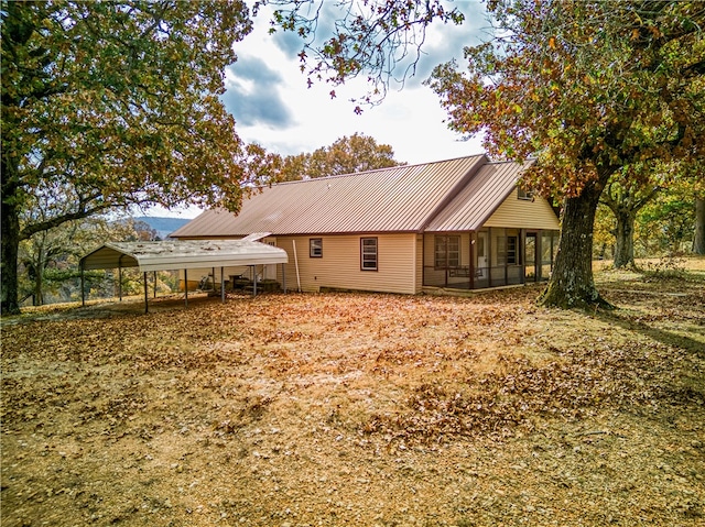 back of property with a sunroom and a carport