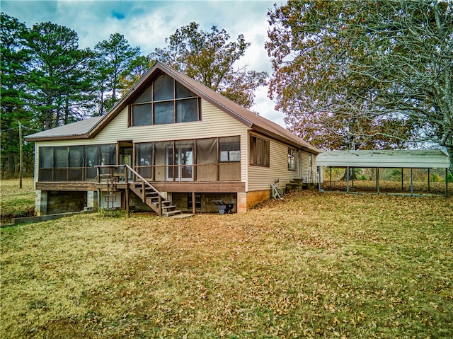 back of property with a sunroom, a lawn, and a carport