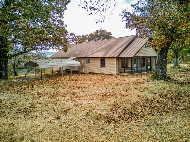 back of property with a carport and a sunroom