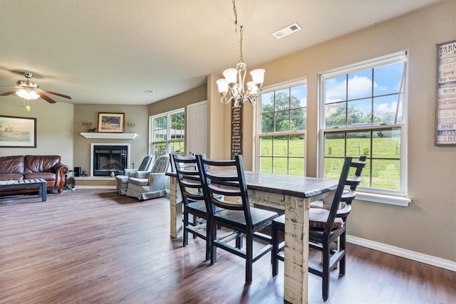 dining area featuring ceiling fan with notable chandelier, plenty of natural light, and dark hardwood / wood-style flooring