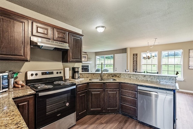 kitchen featuring kitchen peninsula, appliances with stainless steel finishes, dark hardwood / wood-style floors, and plenty of natural light