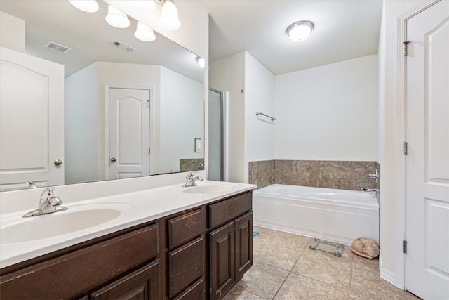 bathroom featuring vanity, a tub to relax in, and tile patterned floors