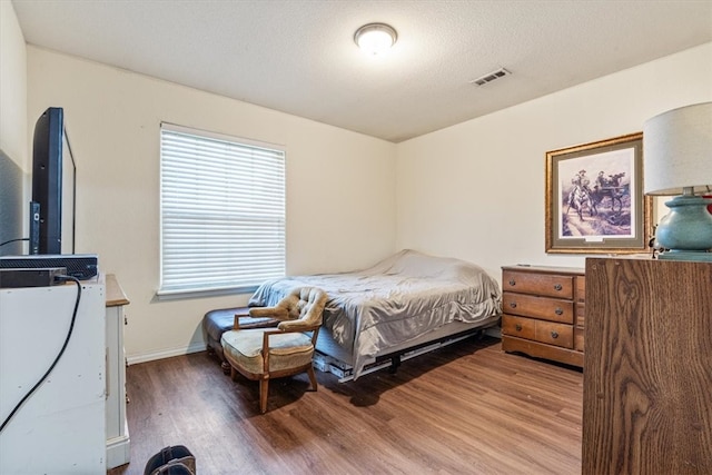 bedroom featuring hardwood / wood-style floors and a textured ceiling