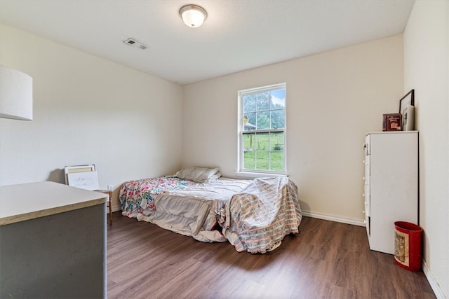 bedroom with dark hardwood / wood-style floors