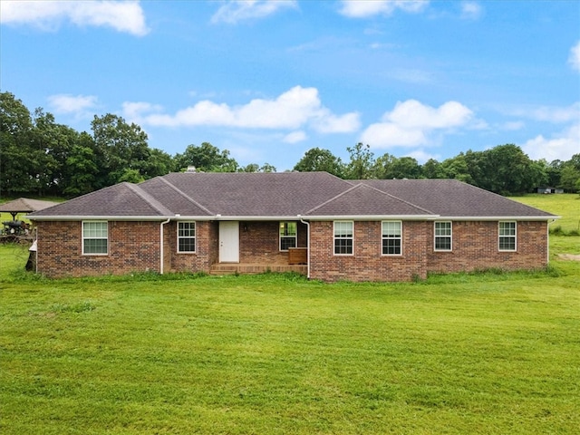 rear view of property featuring a lawn