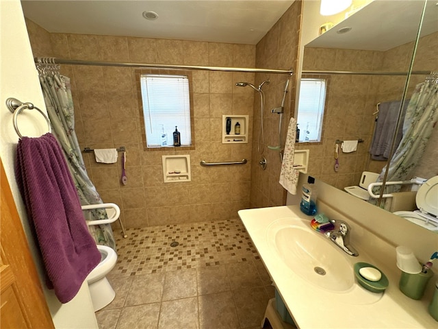 bathroom featuring a shower with shower curtain, vanity, tile patterned floors, and tile walls