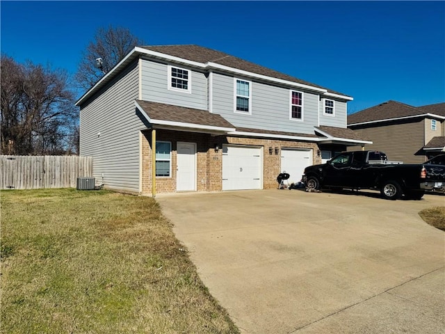 view of property with a garage, a front lawn, and central air condition unit