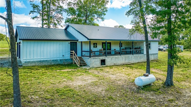 back of house with a porch and a lawn