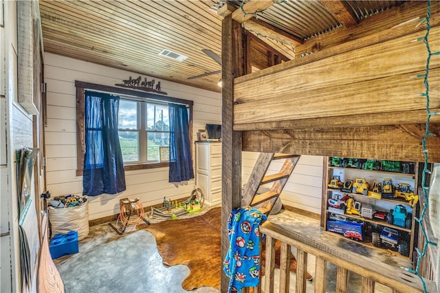 bedroom with wood walls and concrete floors