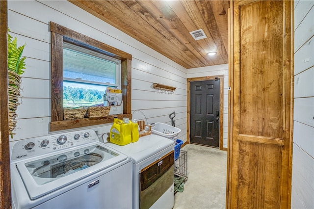 laundry room with wooden walls, independent washer and dryer, light colored carpet, and wood ceiling