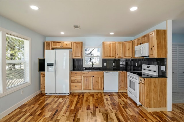 kitchen with white appliances, tasteful backsplash, visible vents, dark countertops, and a sink