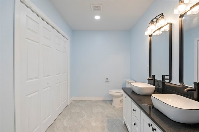 full bath with a closet, visible vents, a sink, and double vanity