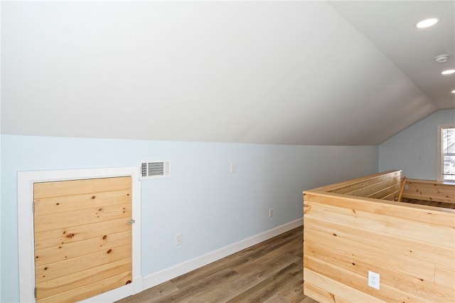 bar featuring baseboards, visible vents, lofted ceiling, wood finished floors, and recessed lighting