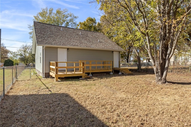 exterior space with a yard, a shingled roof, a fenced backyard, and a wooden deck