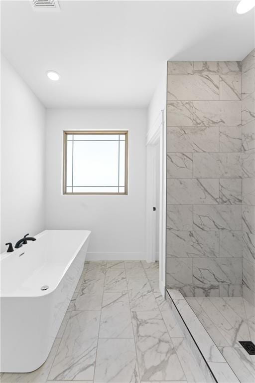 bathroom with a tile shower, marble finish floor, visible vents, and a freestanding tub