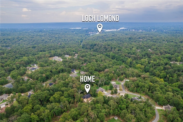 birds eye view of property featuring a wooded view