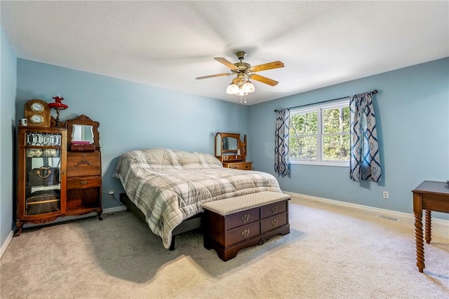 bedroom with visible vents, baseboards, and light carpet