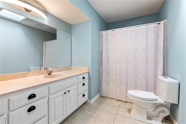 full bath featuring tile patterned floors, baseboards, toilet, and vanity