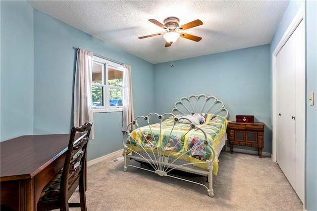 bedroom with a closet, carpet, and a textured ceiling