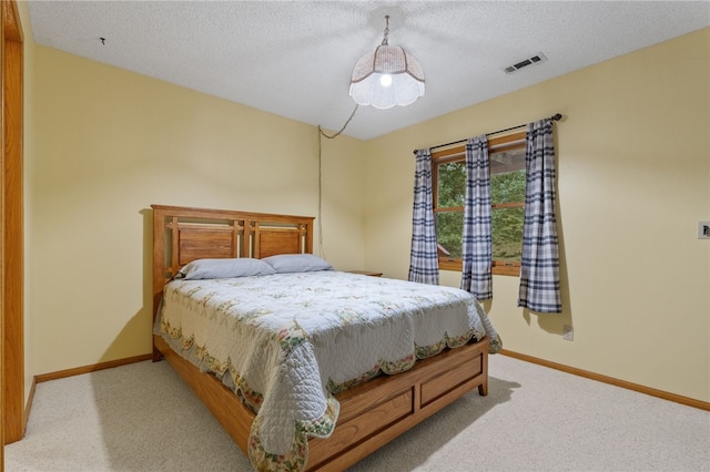 bedroom with visible vents, carpet, baseboards, and a textured ceiling