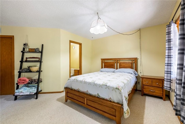 bedroom with light colored carpet, baseboards, and a textured ceiling