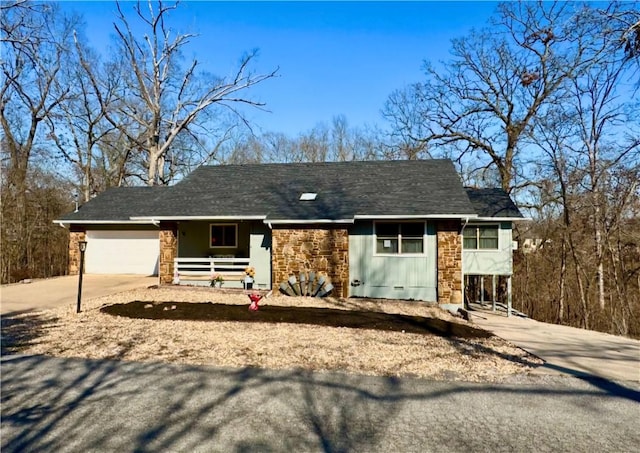 ranch-style house with stone siding, an attached garage, a porch, and driveway